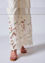 White lace skirt with floral embroidery on a plain background