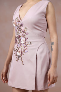 Light pink dress with floral embroidery on a plain background