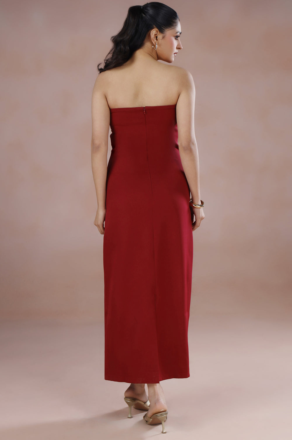 Woman wearing a strapless red dress against a beige background