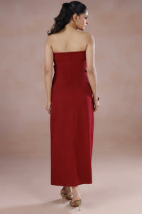 Woman wearing a strapless red dress against a beige background