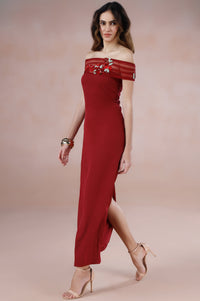 Woman wearing a red off-shoulder dress on a beige background