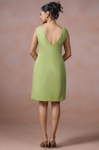 Woman wearing a green dress against a plain background