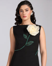 Woman wearing a black dress with a white floral design on a gray background